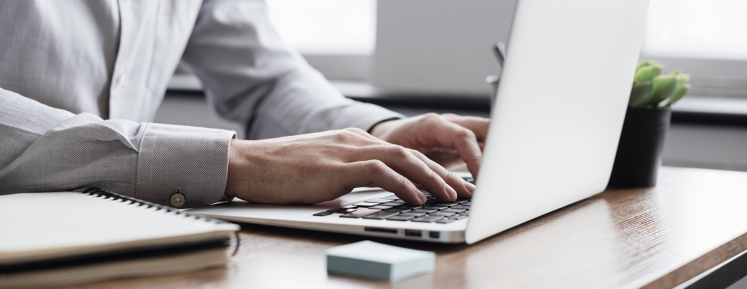Des mains d'homme qui tapent sur un clavier d'ordinateur