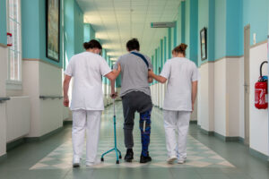 2 médecins autour d'un patient dans un couloir d'hôpital